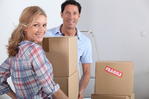 Local removal team handling boxes and furniture in a Docklands apartment move
